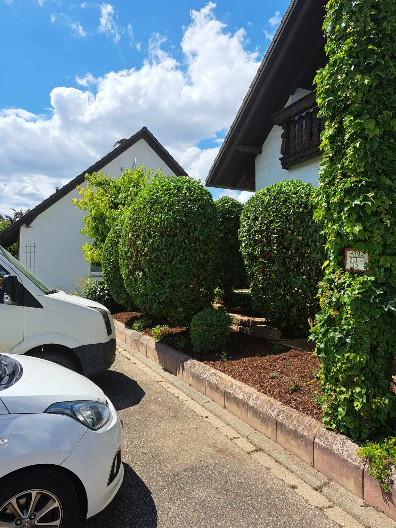 Moderne Villa mit grüner Heckenbepflanzung