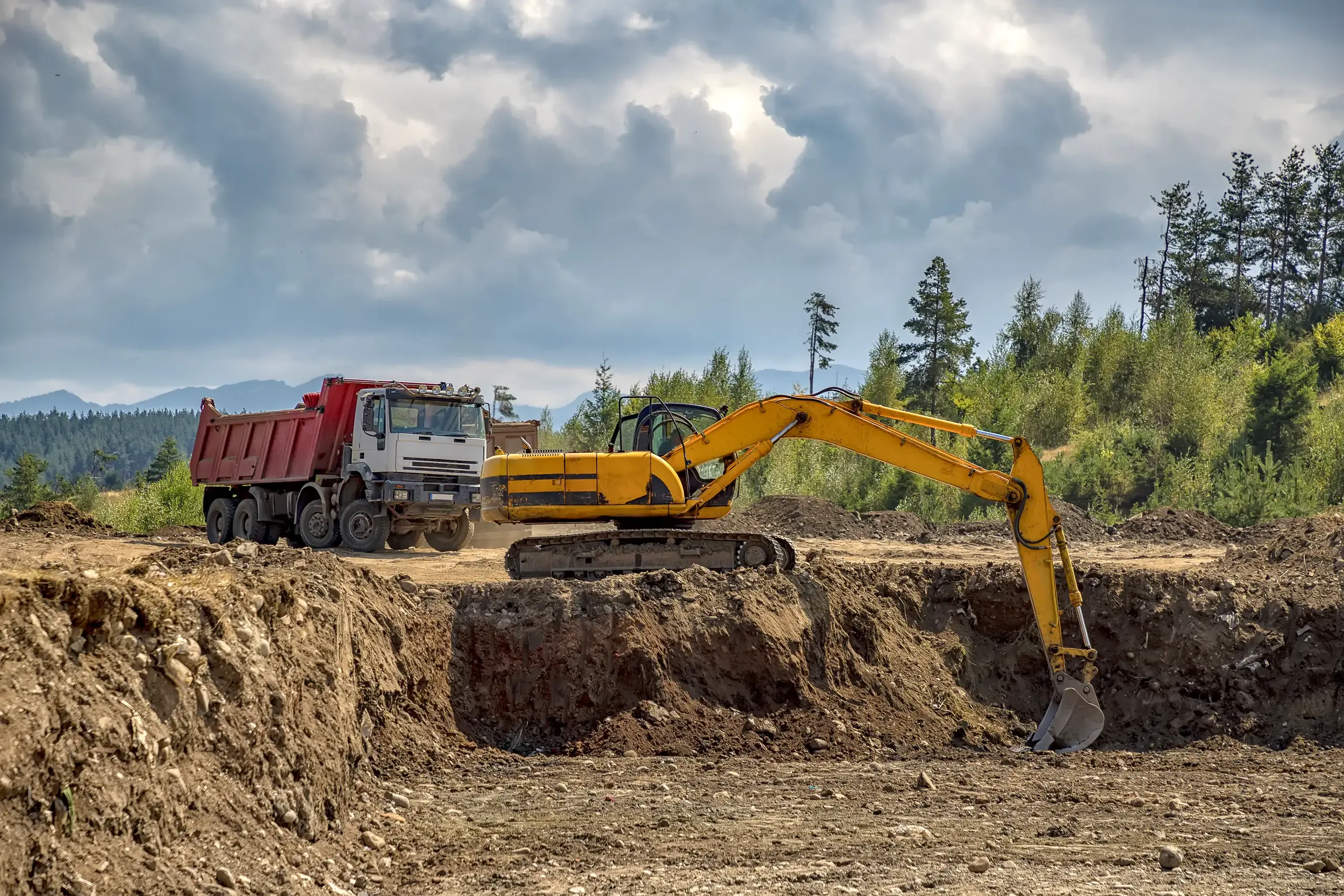 Bagger und Lkw auf einer Baustelle für Abbrucharbeiten und Erdbewegungen
