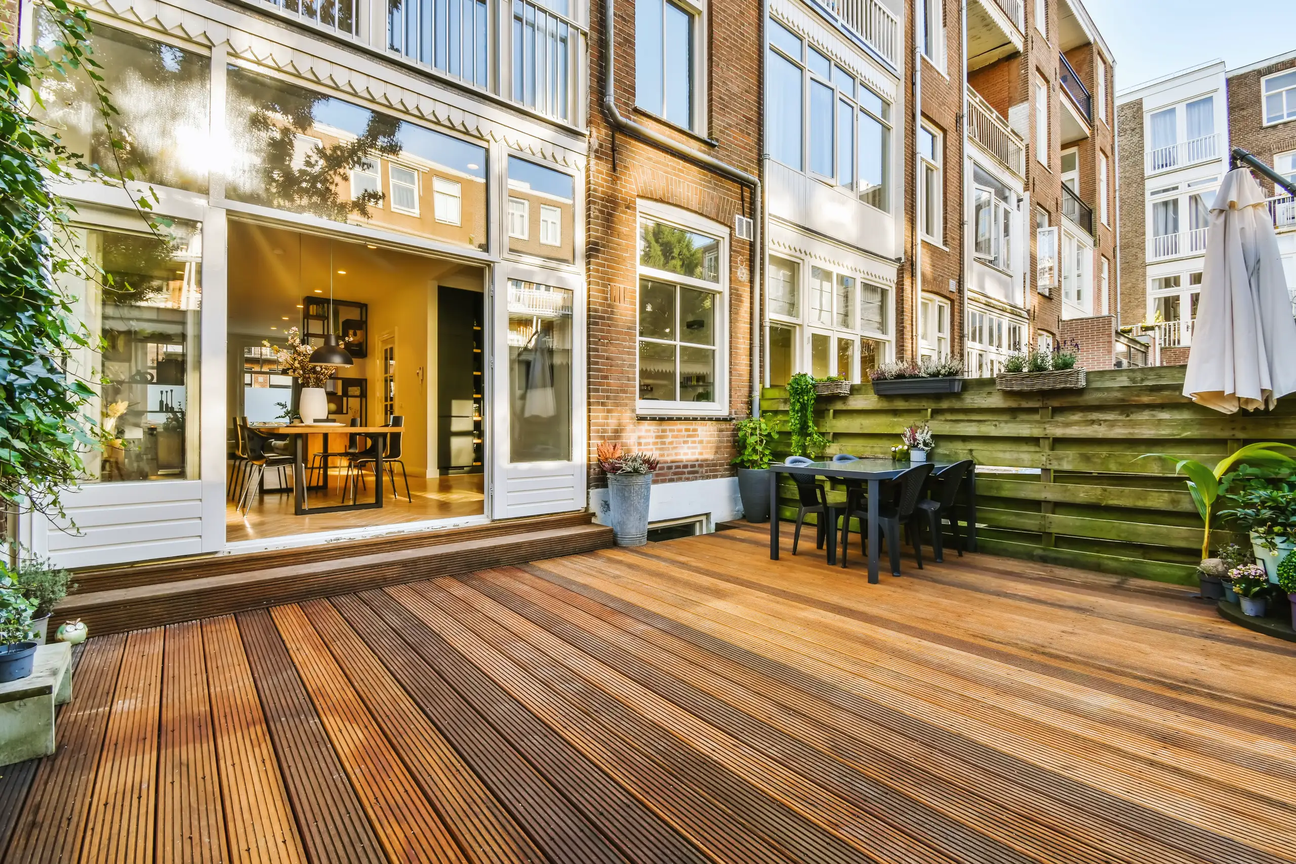 Holzterrasse mit Gartenmöbeln und Blick auf Wohnräume